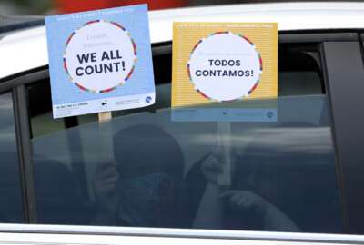 FILE - In this June 25, 2020, file photo, two young children hold signs through the car window that make reference to the 2020 U.S. Census as they wait in the car with their family at an outreach event in Dallas. Thousands of census takers are about to begin the most labor-intensive part of America’s once-a-decade headcount (AP Photo/Tony Gutierrez, File)