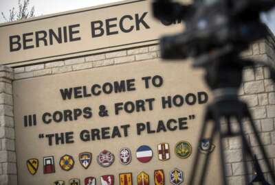 FILE - In this April 2, 2014, file photo, members of the media wait outside of the Bernie Beck Gate, an entrance to the Fort Hood military base in Fort Hood, Texas. Federal agents have seized more than 20 vehicles and the money in 10 bank accounts from a couple of U.S. Army veterans in Texas, who they say used personal information stolen from soldiers to defraud the military out of as much as $11 million. In an affidavit filed in court in June 2020 seeking to search the couple's home in Killeen, near Fort Hood, investigators described how they allegedly used a transportation reimbursement program to swindle the Army out of $2.3 million to $11.3 million. (AP Photo/Tamir Kalifa, File)