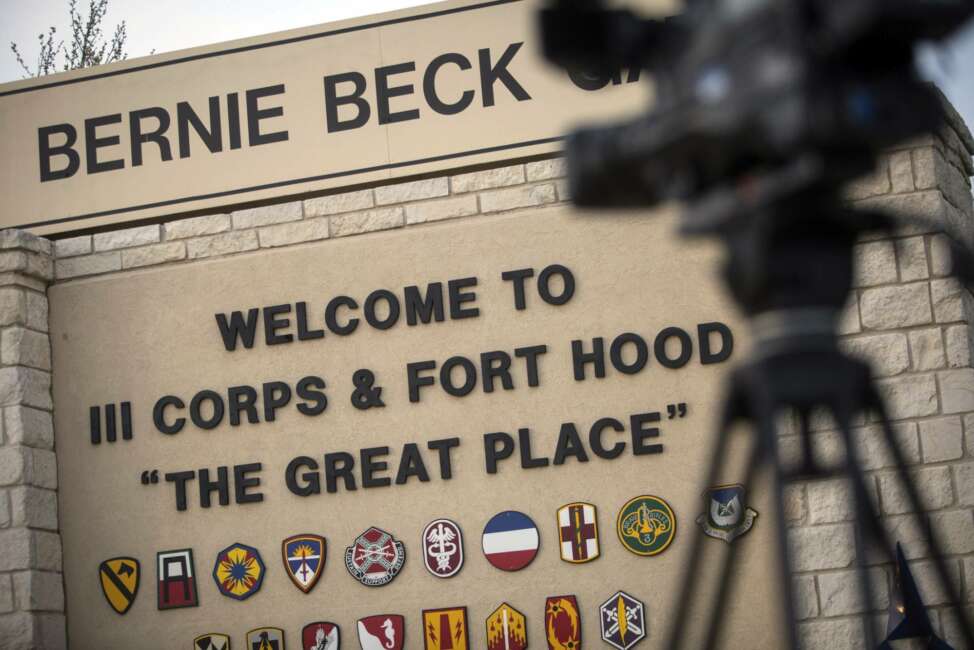 FILE - In this April 2, 2014, file photo, members of the media wait outside of the Bernie Beck Gate, an entrance to the Fort Hood military base in Fort Hood, Texas. Federal agents have seized more than 20 vehicles and the money in 10 bank accounts from a couple of U.S. Army veterans in Texas, who they say used personal information stolen from soldiers to defraud the military out of as much as $11 million. In an affidavit filed in court in June 2020 seeking to search the couple's home in Killeen, near Fort Hood, investigators described how they allegedly used a transportation reimbursement program to swindle the Army out of $2.3 million to $11.3 million. (AP Photo/Tamir Kalifa, File)