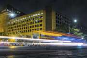 FILE - In this Nov. 1, 2017, file photo, traffic along Pennsylvania Avenue in Washington streaks past the Federal Bureau of Investigation headquarters building. Democrats are accusing President Donald Trump of self-dealing as the White House pushes Senate Republicans to include nearly $1.8 billion to rebuild the FBI headquarters in downtown Washington as part of a new coronavirus aid package. Democrats have long accused Trump of a conflict of interest over the FBI building, which sits across the street from a downtown hotel that Trump owns on Pennsylvania Avenue, blocks from the White House. The Trump International Hotel could face competition if the FBI moves from the current site and another hotel is developed on the property.  (AP Photo/J. David Ake)