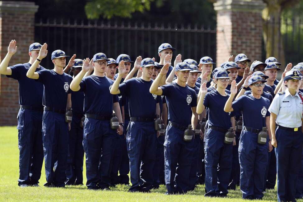 FILE — In this July 1, 2019 file photo, members of the U.S. Coast Guard Academy Class of 2023 take their oath of office on the first day of Swab Summer in New London, Conn. The school, like other service academies and military training centers, has made major changes because of the coronavirus pandemic. That means the eight weeks of boot camp for new cadets, known as "Swab Summer," will be much different. There will be no haircuts, no drilling, no running as a group from place to place, no lining up against the wall in the hall of the barracks for pushups. (Sean D. Elliot//The Day via AP, File)