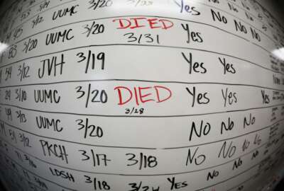 FILE - This Wednesday, May 13, 2020, file photo made with a fisheye lens shows a list of the confirmed COVID-19 cases in Salt Lake County early in the coronavirus pandemic at the county health department in Salt Lake City. Health officials later moved to tracking the cases in an online database, but the white board remains in the office as a reminder of how quickly the coronavirus spread. (AP Photo/Rick Bowmer)