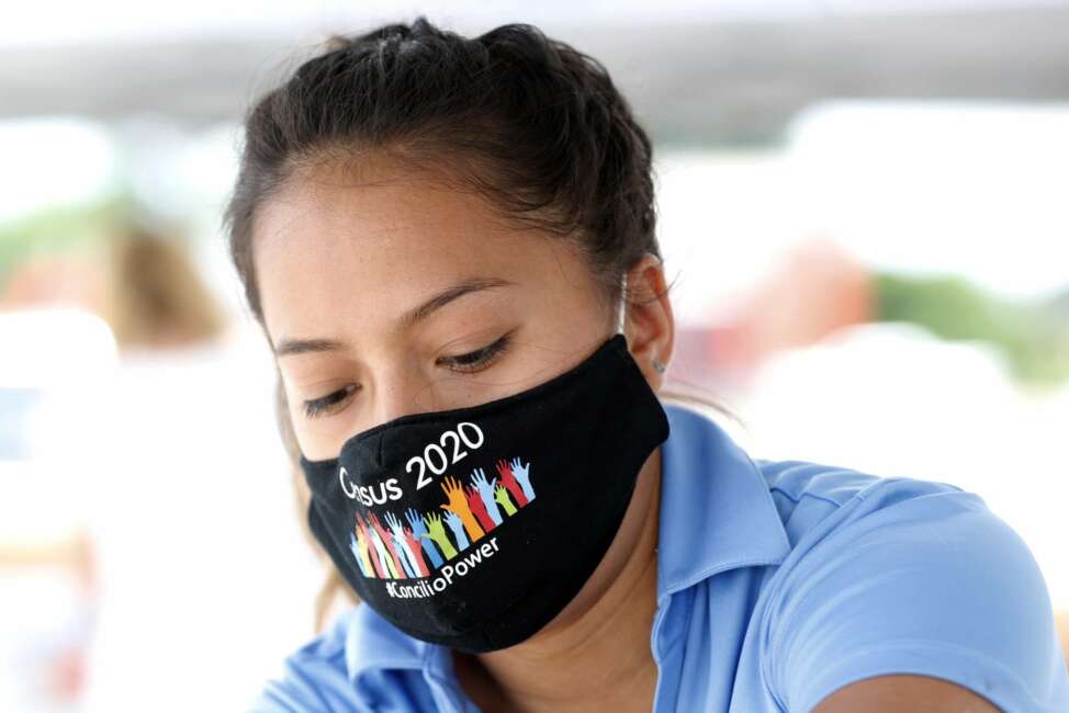 Abigail Hernandez, a staff member with the nonprofit group, The Concilio, helps prepare bags of food being distributed at a 2020 U.S. Census outreach event in Dallas, Thursday, June 25, 2020. In a collaborative effort, the nonprofit group partnered with the North Texas Food Bank, Catholic Charities Dallas and Bachman Lake Together, to hold the event where area residents were encouraged to report their family numbers to the U.S. Census. The outreach event was held in the Bachman Lake community which historically is one of many undercounted neighborhoods in Dallas County according to The Concilio. Due to COVID-19, the Census self-respond date online, by phone or mail has been extended to Oct. 31. (AP Photo/Tony Gutierrez)