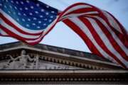 FILE - In this March 22, 2019 file photo, an American flag flies outside the Department of Justice in Washington.  The Justice Department has seized millions of dollars from cryptocurrency accounts that militant organization abroad, including al-Qaida and the Islamic State group, relied on to raise money for their operations, officials announced Thursday.  (AP Photo/Andrew Harnik)