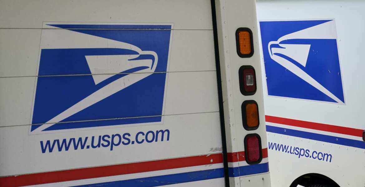 Mail delivery vehicles are parked outside a post office in Boys Town, Neb., Tuesday, Aug. 18, 2020. The Postmaster general announced Tuesday he is halting some operational changes to mail delivery that critics warned were causing widespread delays and could disrupt voting in the November election. Postmaster General Louis DeJoy said he would 