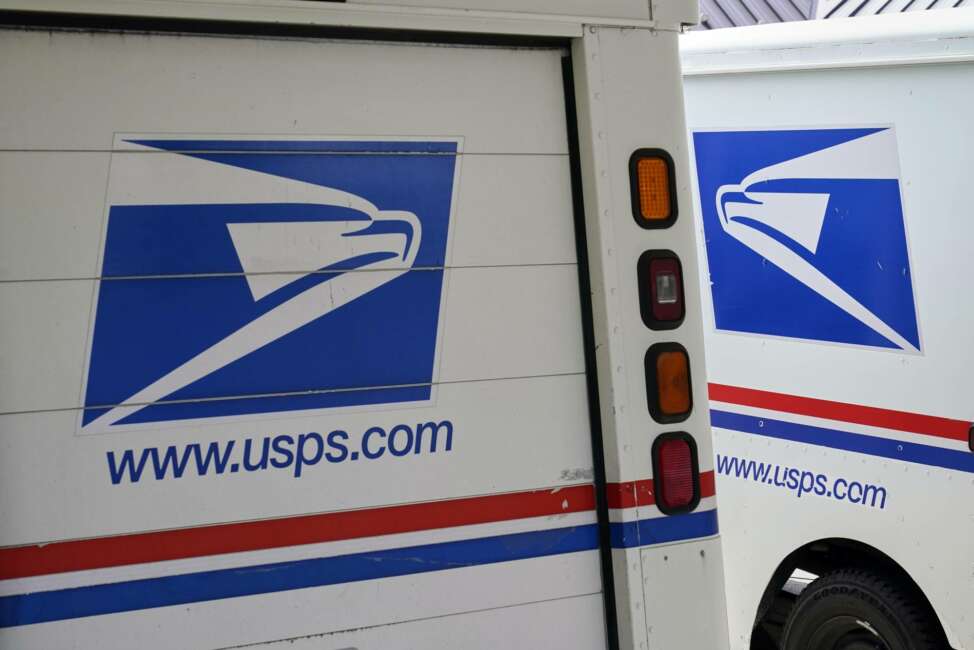 Mail delivery vehicles are parked outside a post office in Boys Town, Neb., Tuesday, Aug. 18, 2020. The Postmaster general announced Tuesday he is halting some operational changes to mail delivery that critics warned were causing widespread delays and could disrupt voting in the November election. Postmaster General Louis DeJoy said he would "suspend" his initiatives until after the election "to avoid even the appearance of impact on election mail." (AP Photo/Nati Harnik)