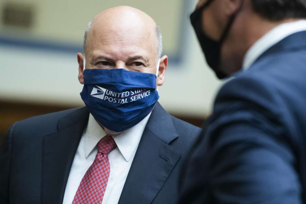 Postmaster General Louis DeJoy, left, talks with Rep. Mark Walker, R-N.C., before a House Oversight and Reform Committee hearing on the Postal Service on Capitol Hill, Monday, Aug. 24, 2020, in Washington. (Tom Williams/Pool via AP)