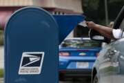 A man mails a letter on Saturday, August 22, 2020 in Whitehall, Ohio. Postal workers and supporters across central Ohio gathered at Post Offices across the region to protest actions by Postmaster General Louis DeJoy including the removal of sorting machines which has led to mail delivery delays in some states. Critics of these policies fear they will create delays with absentee and mail-in ballots during the upcoming general election. (Joshua A. Bickel/The Columbus Dispatch via AP)