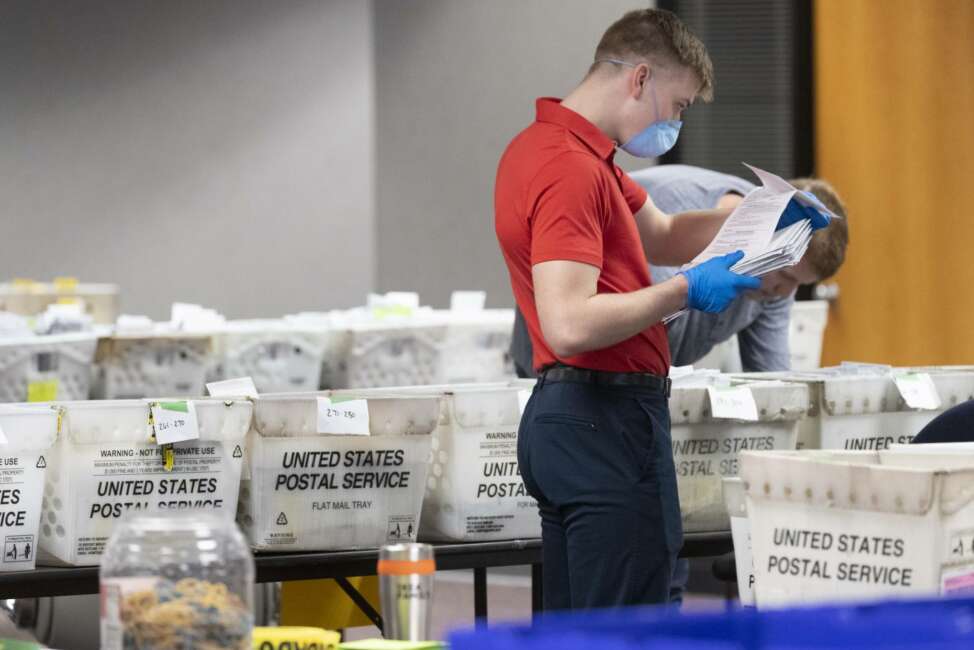 FILE - In this April 8, 2020 file photo, a City of Milwaukee Election Commission worker processes and sorts absentee ballots for Wisconsin's primary election, in downtown Milwaukee, Wis. U.S. Postal Service warnings that it can’t guarantee ballots sent by mail will arrive on time have put a spotlight on the narrow timeframes most states allow to request and return those ballots. (Mark Hoffman/Milwaukee Journal-Sentinel via AP, File)