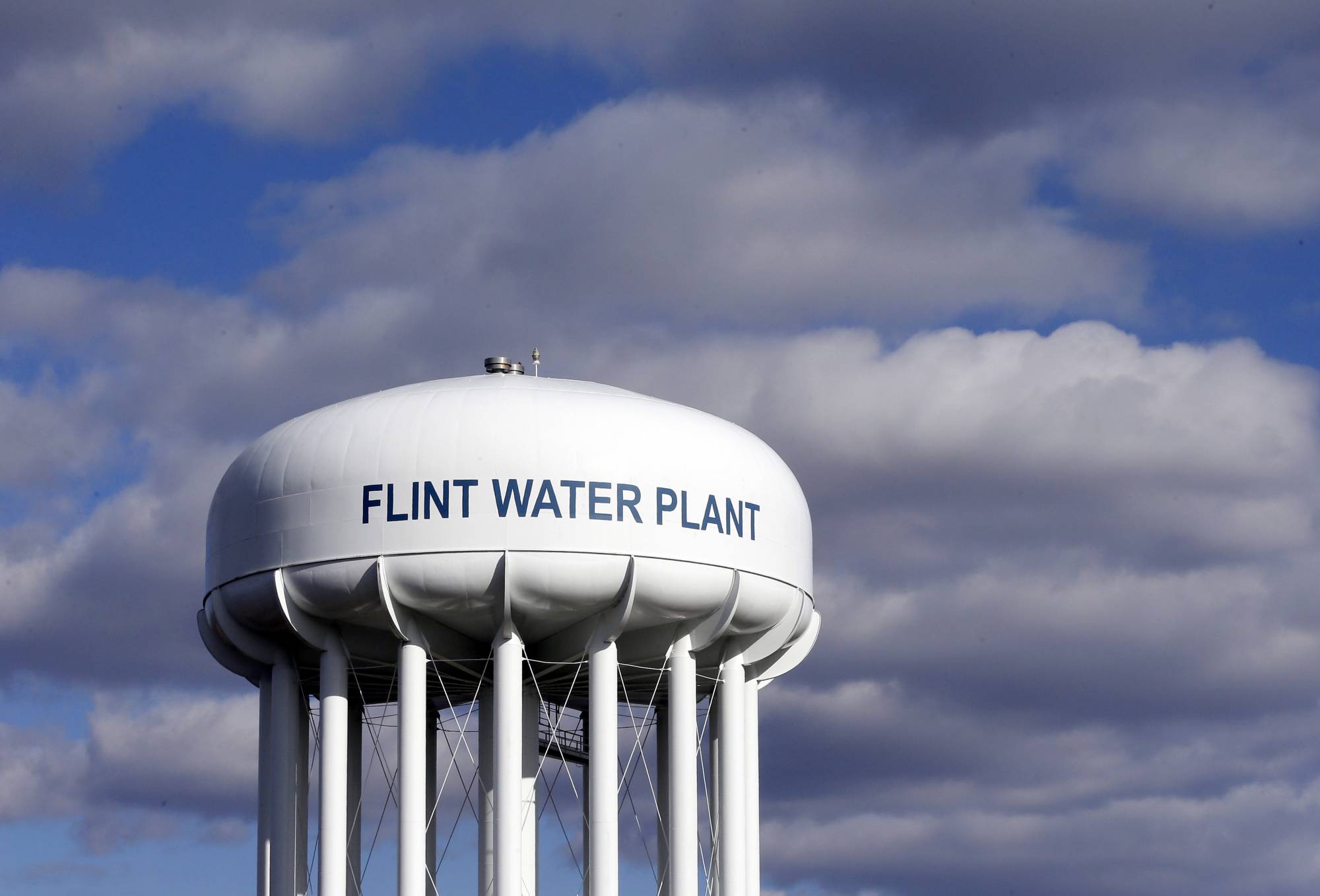 FILE - In this March 21, 2016, file photo, the Flint Water Plant water tower is seen in Flint, Mich. Michigan Gov. Gretchen Whitmer says a proposed $600 million deal between the state of Michigan and Flint residents harmed by lead-tainted water is a step toward making amends. Officials announced the settlement Thursday, Aug. 20, 2020, which must be approved by a federal judge.  (AP Photo/Carlos Osorio, File)