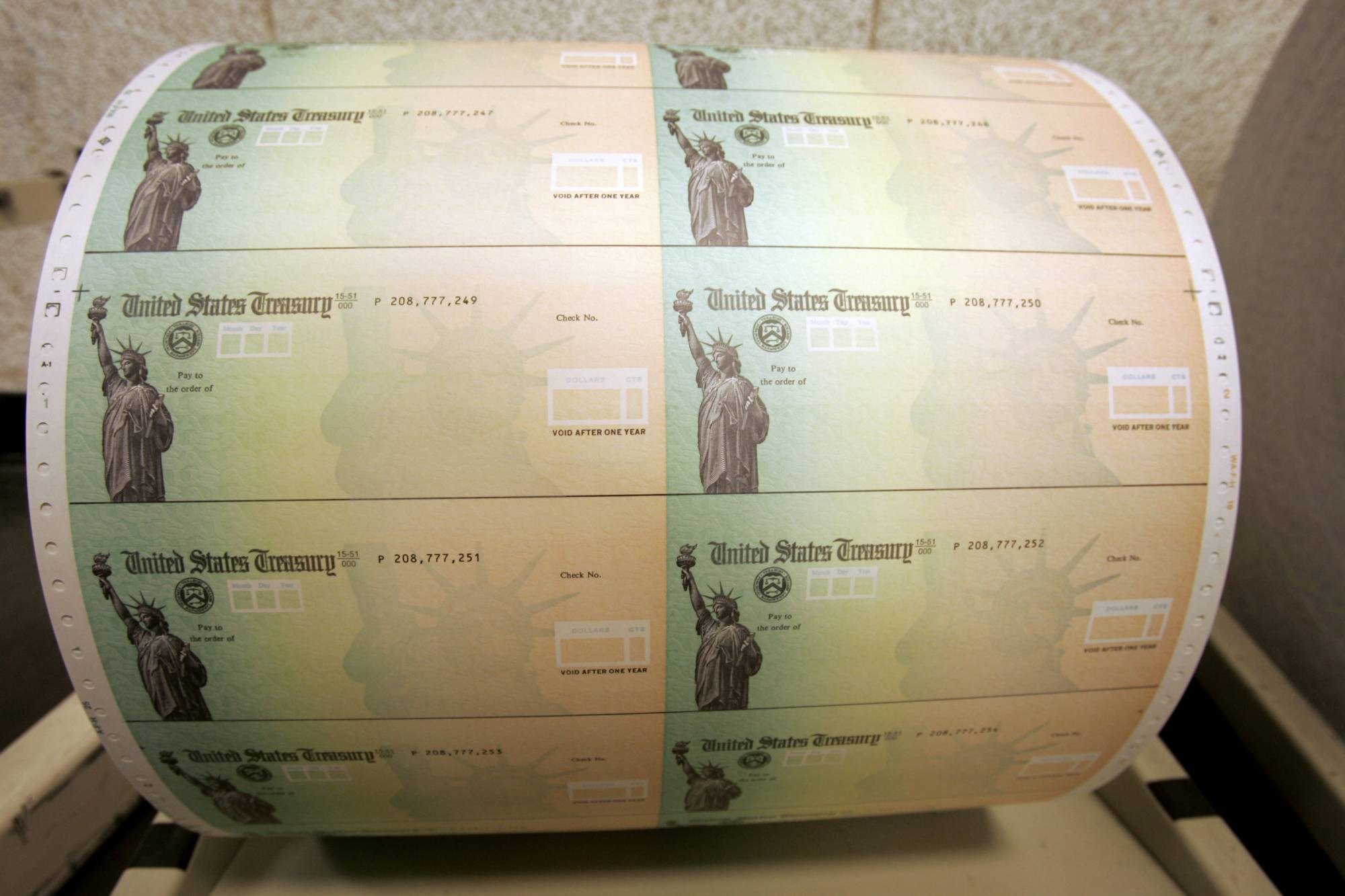 FILE - In this May 8, 2008 file photo, blank U.S. Treasury checks are seen on a roll at the Philadelphia Financial Center, which disburses payments on behalf of federal agencies, in Philadelphia. On Friday, Aug. 21, 2020, The Associated Press reported on stories circulating online incorrectly asserting that the argument that Americans rely on the United States Postal Service for Social Security benefits is invalid because the Social Security Administration stopped mailing paper checks in 2013. The SSA encourages Americans to create digital accounts and receive their benefits electronically, but hundreds of thousands of users still count on the USPS to get their checks every month. (AP Photo/Matt Rourke, File)