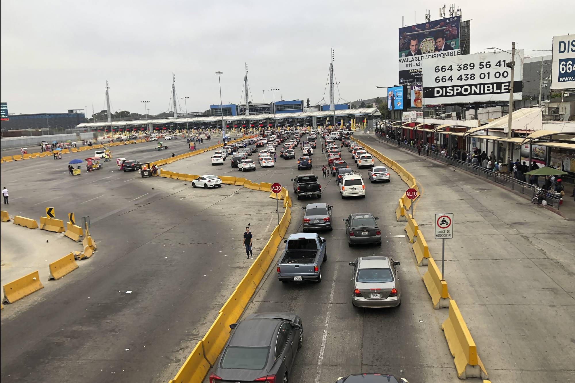 Cars wait in line to enter the United States at San Diego's San Ysidro border crossing, Tuesday, Aug. 25, 2020, in Tijuana, Mexico. A Trump administration crackdown on nonessential travel coming from Mexico amid the coronavirus pandemic has created massive bottlenecks at the border, with drivers reporting waits of up to 10 hours to get into the U.S. (AP Photo/Elliot Spagat)