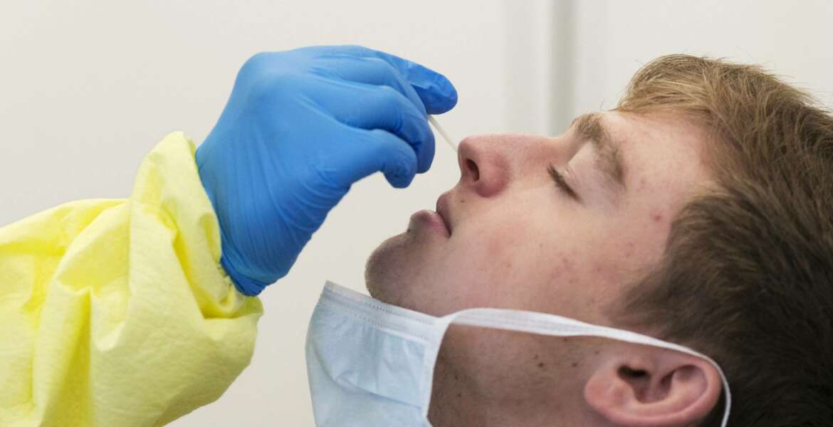 FILE- In this July 8, 2020 file photo, Eric Antosh has a nasal swab taken by a nurse at a COVID-19 testing site in the Brooklyn borough of New York. New York broke a COVID-19 testing record Friday, July 31, 2020, by conducting 82,737 tests, the highest number ever conducted in a single day in the state, Gov. Andrew Cuomo announced on Saturday in a written statement. (AP Photo/Mark Lennihan, File)