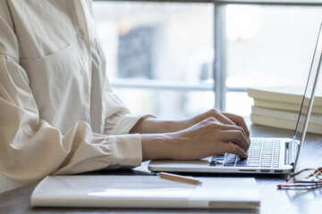 The hand of a young woman working at remote work