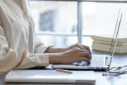 The hand of a young woman working remotely