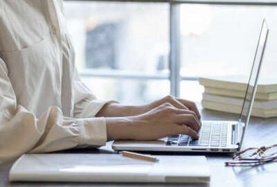 The hand of a young woman working remotely