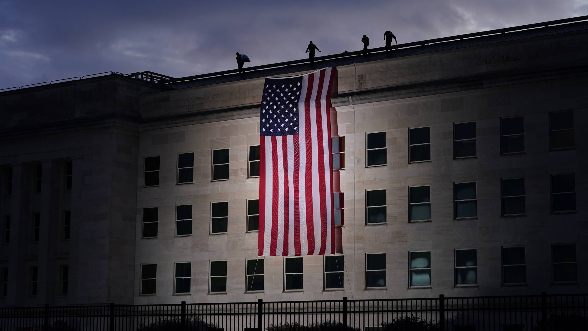 A large American flag is unfurled at the Pentagon ahead of ceremonies at the National 9/11 Pentagon Memorial to honor the 184 people killed in the 2001 terrorist attack on the Pentagon, in Washington, Friday Sept. 11, 2020. (AP Photo/J. Scott Applewhite)