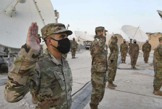In this photo released by the U.S. Air Force, Airmen deployed to Al-Udeid Air Base, Qatar, raise their right hands during an enlistment ceremony as they transferred into the Space Force at Al-Udeid Air Base, Qatar, Tuesday, Sept. 1, 2020. Space Force now has a squadron of 20 members stationed at the Qatari base in its first foreign deployment. The force represents the sixth branch of the U.S. military and the first new military service since the creation of the Air Force in 1947. (Staff Sgt. Kayla White/U.S. Air Force via AP)
