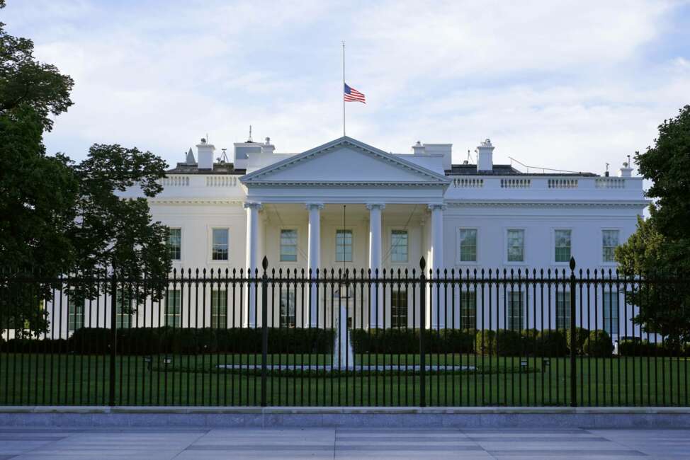 FILE - In this Saturday, Sept. 19, 2020, file photo, an American flag flies at half-staff over the White House in Washington. A woman suspected of sending an envelope containing the poison ricin, which was addressed to White House, has been arrested at the New York-Canada border. (AP Photo/Patrick Semansky, File)