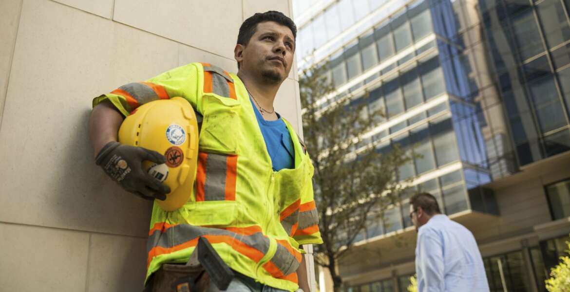 This undated photo provided by Panda Bear Films/Latino Public Broadcasting shows Latino construction worker stands outside a Dallas construction site. 