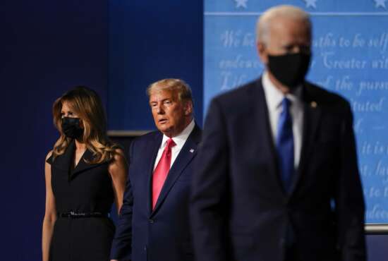 first lady Melania Trump, left, and President Donald Trump, center, remain on stage as Democratic presidential candidate former Vice President Joe Biden, right, walk away at the conclusion of the second and final presidential debate Thursday, Oct. 22, 2020, at Belmont University in Nashville, Tenn. (AP Photo/Julio Cortez)