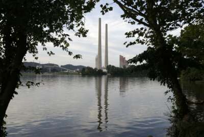 FILE  - In this Aug. 7, 2019, photo, the Kingston Fossil Plant stands near a waterway in Kingston, Tenn. The Trump administration will let some leaking or otherwise dangerous coal ash storage ponds stay in operation for years more and some unlined ponds stay open indefinitely under a rule change announced Friday, Oct. 16, 2020.  In 2008, the six-story-tall dike on a massive coal ash pond at the Tennessee plant collapsed, releasing more than a billion gallons of coal ash into the Swan Pond community. It remains the largest industrial spill in modern U.S. history and prompted the 2015 regulations that were intended to increase oversight of the industry. (AP Photo/Mark Humphrey, File)