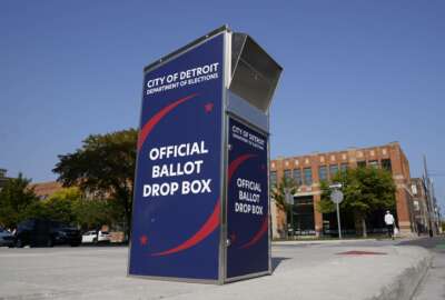 FILE - In this Thursday, Sept. 24, 2020, file photo, a ballot drop box is shown where voters can drop off absentee ballots instead of using the mail outside the Detroit Pistons training facility in Detroit. NFL, NBA, NHL, Major League Baseball and college venues are serving various roles in unprecedented ways, including providing space for people to vote while social distancing on Election Day. (AP Photo/Paul Sancya, File)