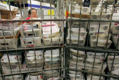 A worker sorts mail at a USPS Mailroom