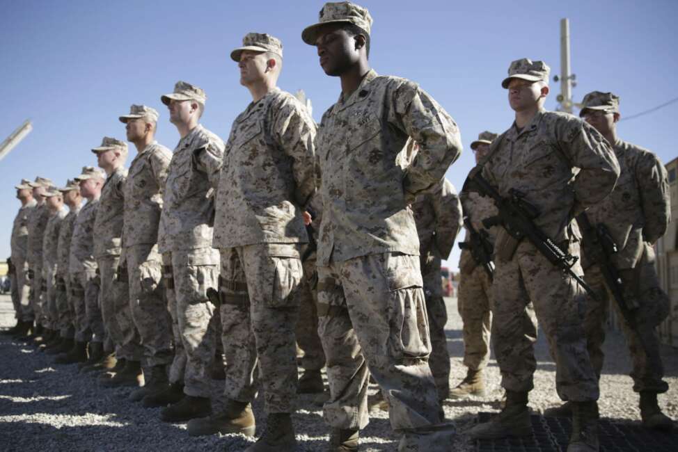 FILE - In this Jan. 15, 2018, file photo, U.S. Marines watch during the change of command ceremony at Task Force Southwest military field in Shorab military camp of Helmand province, Afghanistan. An accelerated U.S. troop withdrawal from Afghanistan, announced by Washington, Tuesday, Nov. 17, 2020, has rattled both allies and adversaries and raised fears of worsening violence and regional chaos, which some say could embolden the Islamic State affiliate in the country to try to regroup in a lawless Afghanistan. (AP Photo/Massoud Hossaini, File)