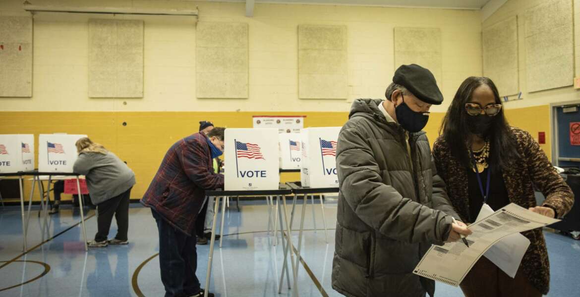 Election worker Robin Smith helps a voter with his ballot Tuesday, Nov. 3, 2020, at Willow School in Lansing, Mich. [Matthew Dae Smith/Lansing State Journal via AP)