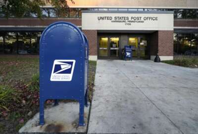 A mailbox sits outside a U.S. Post Office building, Tuesday, Nov. 3, 2020, in the Susquehanna Township section of Harrisburg, Pa. U.S. Postal Service inspectors found just 13 ballots during an Election Day sweep of processing centers ordered by a federal judge, all of them in Pennsylvania. Court documents filed Wednesday, Nov. 4, 2020, say the ballots were then expedited for delivery to local election offices.  (AP Photo/Julio Cortez, File)