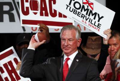Republican Senator-elect Tommy Tuberville throws toy footballs to supporters at his watch party at the Renaissance Hotel on Tuesday, Nov. 3, 2020, in Montgomery, Ala. (AP Photo/Butch Dill)