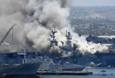 FILE - In this July 12, 2020, file photo, smoke rises from the USS Bonhomme Richard at Naval Base San Diego in San Diego, after an explosion and fire onboard the ship at Naval Base San Diego. The Navy on Monday, Nov. 30, 2020, said that it will decommission the warship docked off San Diego after suspected arson caused extensive damage, making it too expensive to restore. (AP Photo/Denis Poroy, File)