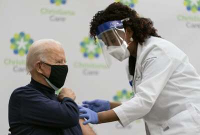 President-elect Joe Biden receives his first dose of the coronavirus vaccine from Nurse partitioner Tabe Mase at Christiana Hospital on live television in Newark Del., Monday, Dec. 21, 2020. (AP Photo/Carolyn Kaster)