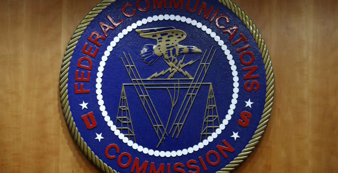 FILE - In this Dec. 14, 2017, file photo, the seal of the Federal Communications Commission (FCC) is seen before an FCC meeting to vote on net neutrality in Washington. The Senate has narrowly approved President Donald Trump’s lame-duck nominee, Nathan Simington, on Tuesday, Dec. 8, 2020, to become a member of the Federal Communications Commission. (AP Photo/Jacquelyn Martin, File)