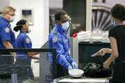 TSA officers wear protective masks at a security screening area at Seattle-Tacoma International Airport Monday, May 18, 2020, in SeaTac, Wash. Airlines say they are stepping up security on flights to Washington before next week’s inauguration of President-elect Joe Biden. Delta, United and Alaska airlines said Thursday, Jan. 14, 2021 they will bar passengers flying to Washington from putting guns in checked bags. (AP Photo/Elaine Thompson)