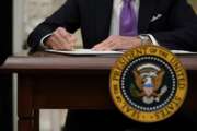 President Joe Biden signs executive orders after speaking about the coronavirus in the State Dinning Room of the White House, Thursday, Jan. 21, 2021, in Washington. (AP Photo/Alex Brandon)