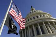 Flags fly on the U.S. Capitol in Washington, Tuesday, Jan. 19, 2021, ahead of the 59th Presidential Inauguration on Wednesday. (AP Photo/Susan Walsh, Pool)