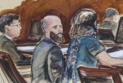 In this Wednesday March 4, 2020 courtroom sketch Joshua Schulte, center, is seated at the defense table flanked by his attorneys during jury deliberations in New York. Joshua Schulte, a former CIA software engineer charged with leaking government secrets to WikiLeaks says it's cruel and unusual punishment that he's awaiting trial in solitary confinement, housed in a vermin-infested cell of a jail unit where inmates are treated like “caged animals.