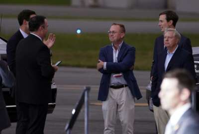 White House social media director Dan Scavino, from left, White House aide John McEntee former acting chief of staff Mick Mulvaney, White House adviser Jared Kushner and Sen. Lindsey Graham, R-S.C., talk as President Donald Trump speaks during a campaign rally at Smith Reynolds Airport, Tuesday, Sept. 8, 2020, in Winston-Salem, N.C. (AP Photo/Evan Vucci)