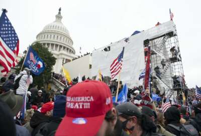 Supporters of President Donald Trump climb on an inauguration platform on the West Front of the U.S. Capitol on Wednesday, Jan. 6, 2021, in Washington. (AP Photo/Jose Luis Magana)