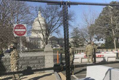 Members of the National Guard stand inside anti-scaling fencing that surrounds the Capitol, Sunday, Jan. 10, 2021, in Washington. Last week’s mob attack on the U.S. Capitol starkly highlighted a longstanding local security paradox: The District of Columbia government lacks authority over much of the area within its borders.  (AP Photo/Alan Fram)