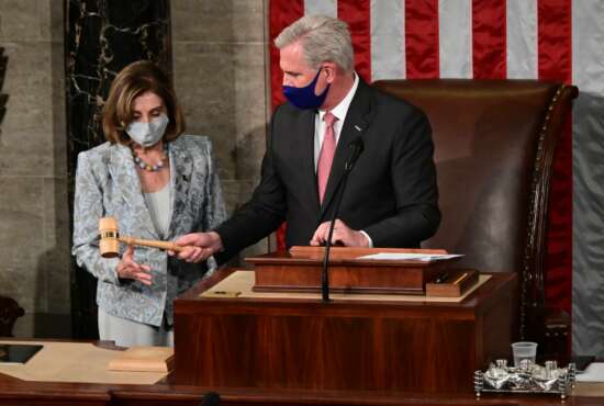 Speaker of the House Nancy Pelosi is handed the Speaker's gavel by House Minority Leader Kevin McCarthy, R-Calif., on the opening day of the 117th Congress on Capitol Hill in Washington, Sunday, Jan. 3, 2021. (Erin Scott/Pool via AP)