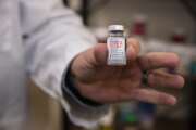 Pharmacist Brian Meyer holds a Moderna COVID-19 vaccine vial for a photo on Tuesday, Jan. 5, 2021 at Sunflower Pharmacy in Odessa, Texas. Sunflower Pharmacy is the first privately owned pharmacy in Odessa given to permission to distribute the vaccine. (Eli Hartman/Odessa American via AP)