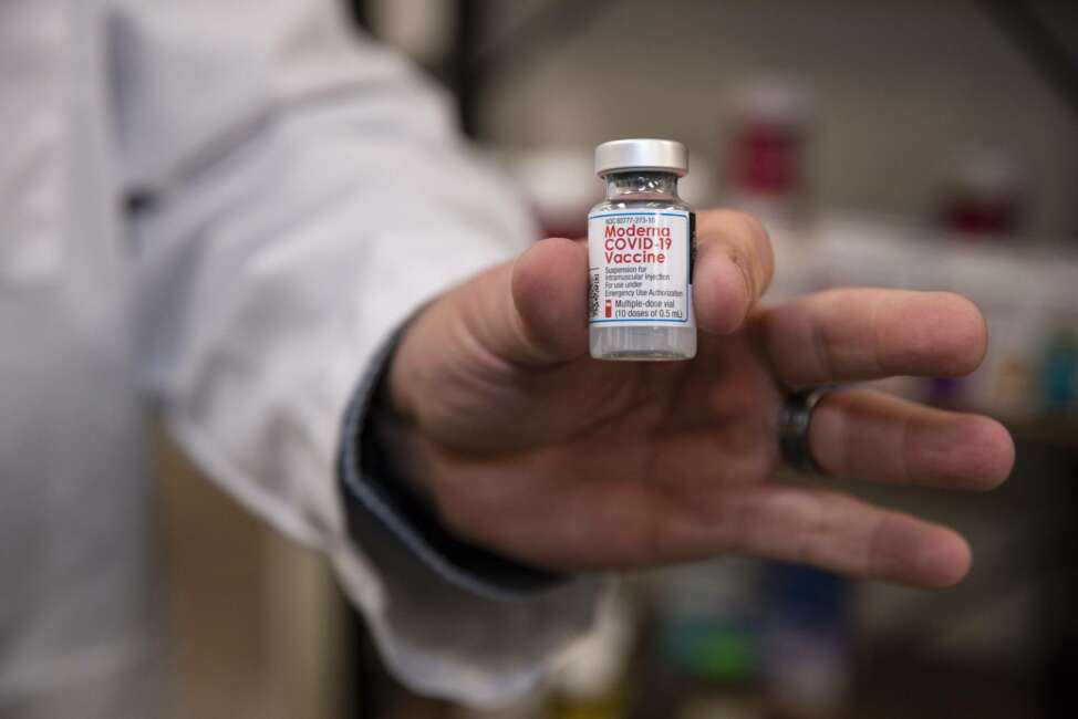 Pharmacist Brian Meyer holds a Moderna COVID-19 vaccine vial for a photo on Tuesday, Jan. 5, 2021 at Sunflower Pharmacy in Odessa, Texas. Sunflower Pharmacy is the first privately owned pharmacy in Odessa given to permission to distribute the vaccine. (Eli Hartman/Odessa American via AP)