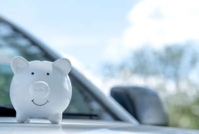 White piggy bank on the car, Money-saving concept for insurance, or traveling during retirement.