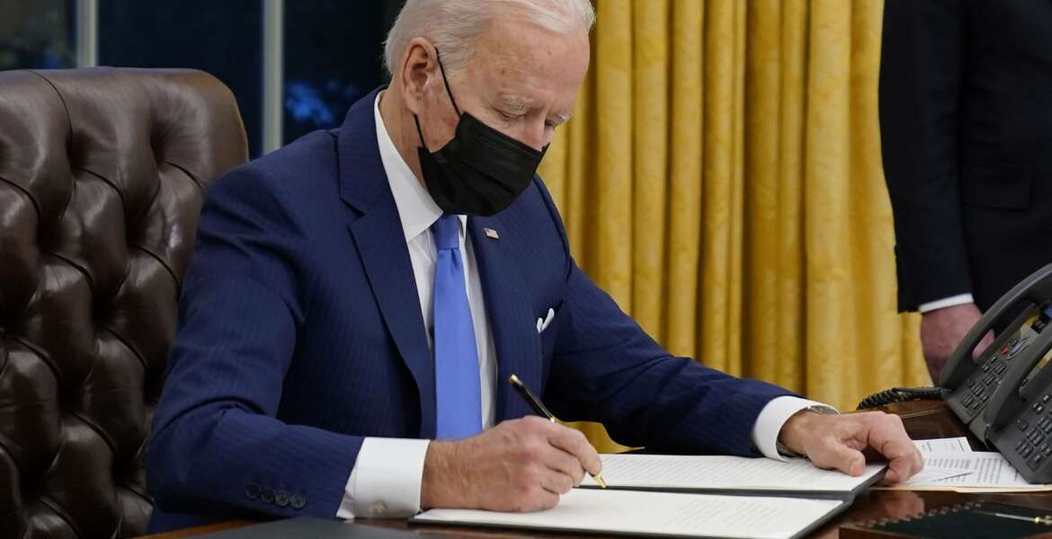 President Joe Biden signs an executive order on immigration, in the Oval Office of the White House, Tuesday, Feb. 2, 2021, in Washington. (AP Photo/Evan Vucci)