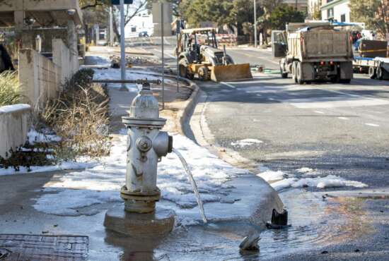 FILE - In this Feb. 21, 2021 file photo, water trickles from a fire hydrant while City of Austin Water Utility workers repair a broken water main in Austin, Texas, due to severe winter weather. The winter storm nightmare knocked out power to more than 4 million customers across the state. On Thursday, Feb. 25 managers of Texas' power grid are expected to receive a verbal lashing in the first public hearings about the crisis at the state Capitol. (Jay Janner/Austin American-Statesman via AP, File)