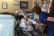 Resident Eleanor Garrison, left, talks with director of nursing Cheri Place-Chafin in her room Wednesday, Feb. 3, 2021, at Arbor Springs Health and Rehabilitation Center in Opelika, Ala. Coronavirus cases have dropped at U.S. nursing homes and other long-term care centers over the past few weeks, offering a glimmer of hope that studies and health officials link to various factors, including the start of vaccinations, the easing of a post-holiday virus surge and better prevention. (AP Photo/Julie Bennett)