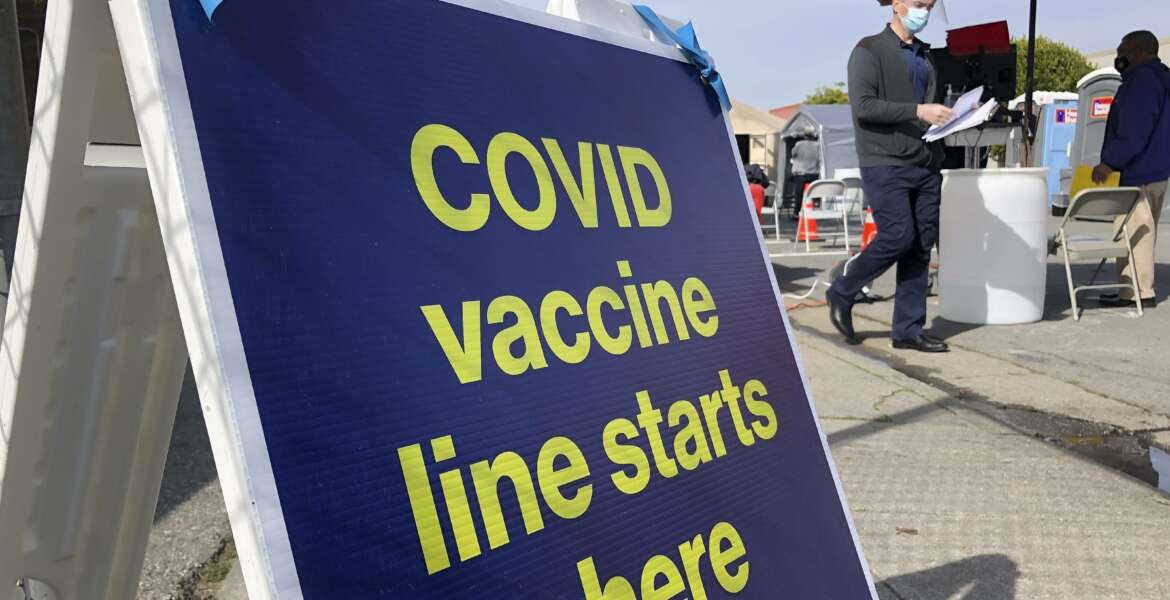 A sign is shown at a COVID-19 vaccine site in the Bayview neighborhood of San Francisco, Monday, Feb. 8, 2021. Counties in California and other places in the U.S. are trying to ensure they vaccinate people in largely Black, Latino and working-class communities that have borne the brunt of the coronavirus pandemic. San Francisco is reserving some vaccines for seniors in the two ZIP codes hit hardest by the pandemic. (AP Photo/Haven Daley)